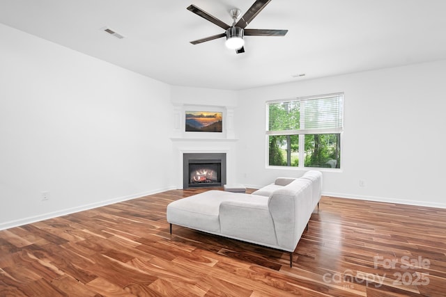 9437 Macquarie Ln, Charlotte, NC 28227 - living area with a ceiling fan, a warm lit fireplace, wood finished floors, and baseboards
