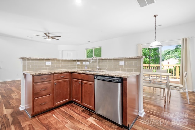 9437 Macquarie Ln, Charlotte, NC 28227 - kitchen with stainless steel dishwasher, a sink, light wood-style floors, and tasteful backsplash