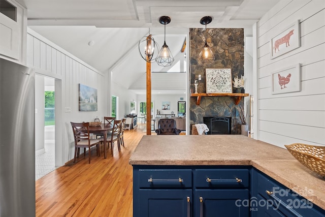 930 Hawley Rd, Mcconnells, SC 29726 - kitchen featuring blue cabinets, freestanding refrigerator, light wood-style flooring, a stone fireplace, and decorative light fixtures