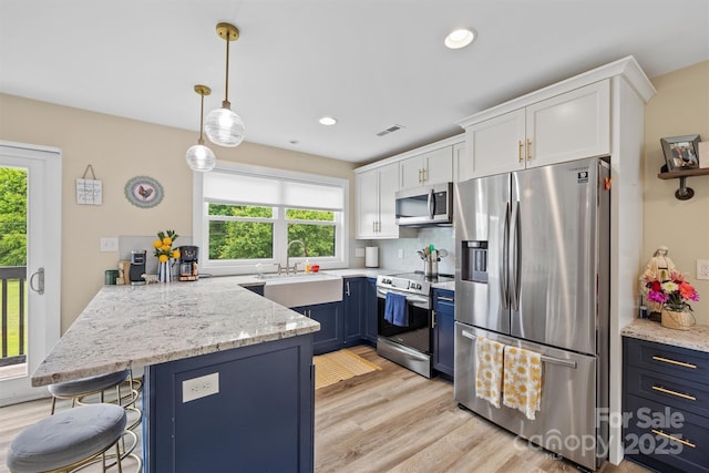 930 Hawley Rd, Mcconnells, SC 29726 - kitchen with appliances with stainless steel finishes, white cabinets, a peninsula, light wood finished floors, and light stone countertops