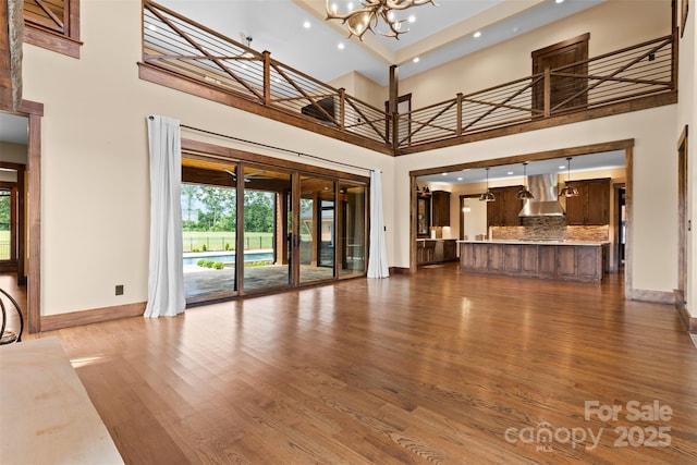 1822 Irby Rd, Monroe, NC 28112 - unfurnished living room with a high ceiling, baseboards, dark wood-type flooring, a chandelier, and recessed lighting
