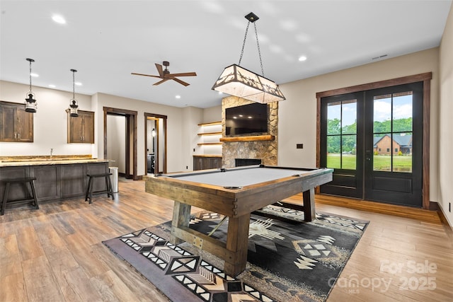 1822 Irby Rd, Monroe, NC 28112 - recreation room with light wood finished floors, a stone fireplace, recessed lighting, french doors, and ceiling fan