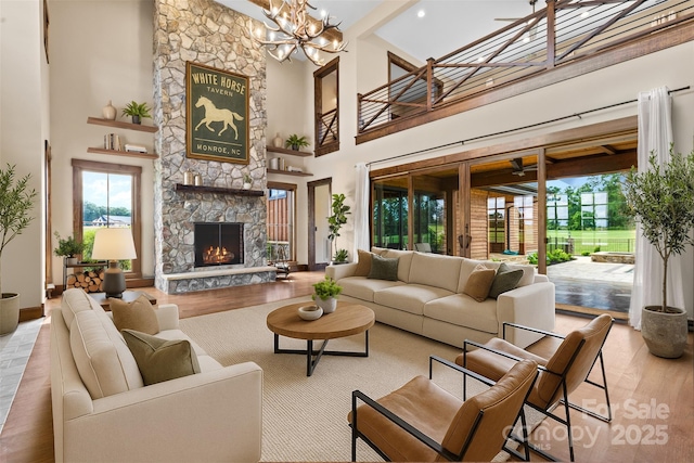 1822 Irby Rd, Monroe, NC 28112 - living room with a towering ceiling, a stone fireplace, wood finished floors, a chandelier, and baseboards