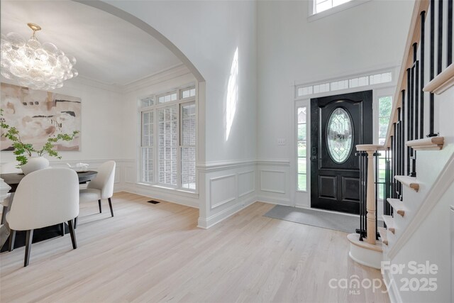 3741 Tea Olive Rd, Gastonia, NC 28056 - foyer entrance with arched walkways, wood finished floors, a chandelier, wainscoting, and a decorative wall