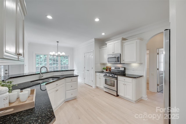 3741 Tea Olive Rd, Gastonia, NC 28056 - kitchen featuring appliances with stainless steel finishes, a sink, arched walkways, ornamental molding, and white cabinetry