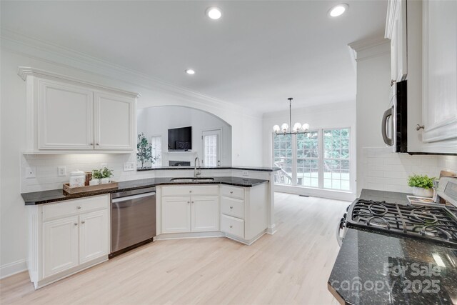 3741 Tea Olive Rd, Gastonia, NC 28056 - kitchen with appliances with stainless steel finishes, a peninsula, white cabinets, light wood-style floors, and a chandelier