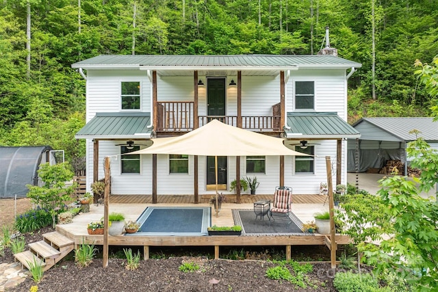 6470 Stone Mountain Rd, Lenoir, NC 28645 - rear view of house with a balcony, a forest view, an outbuilding, and metal roof