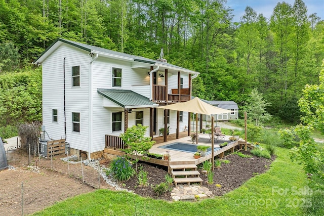6470 Stone Mountain Rd, Lenoir, NC 28645 - back of house with a balcony, a deck, a forest view, and metal roof