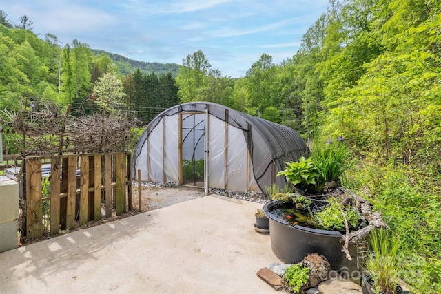 6470 Stone Mountain Rd, Lenoir, NC 28645 - view of patio with an exterior structure, an outdoor structure, and a wooded view