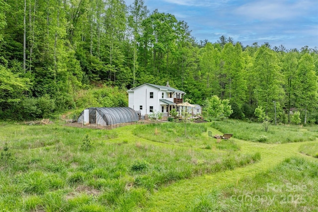 6470 Stone Mountain Rd, Lenoir, NC 28645 - view of yard featuring a forest view, an outdoor structure, a wooden deck, and a greenhouse