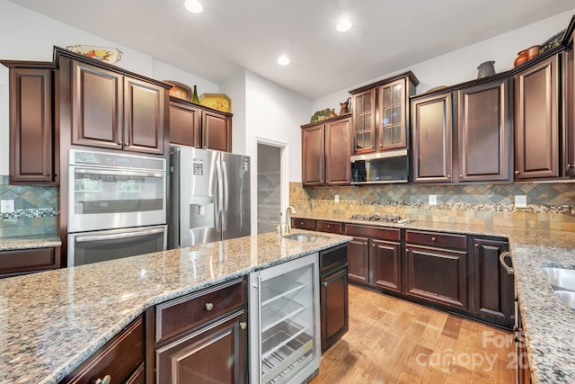 8336 Early Bird Way, Mint Hill, NC 28227 - kitchen featuring beverage cooler, stainless steel appliances, light stone countertops, light wood-style flooring, and tasteful backsplash