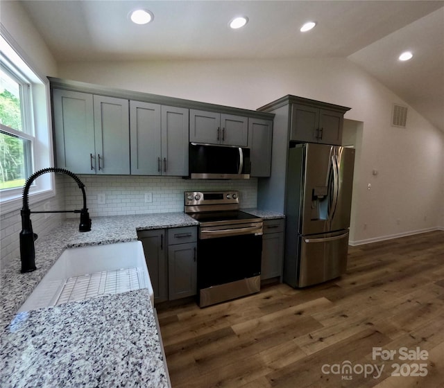 280 Haven Ridge Ln N, Marion, NC 28752 - kitchen featuring appliances with stainless steel finishes, vaulted ceiling, a sink, tasteful backsplash, and wood finished floors