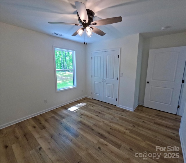 280 Haven Ridge Ln N, Marion, NC 28752 - unfurnished bedroom featuring wood finished floors, baseboards, a closet, and ceiling fan