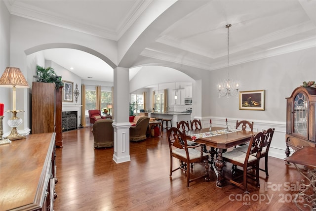 2021 Pinyon Ln, Lancaster, SC 29720 - dining area featuring dark wood-type flooring, arched walkways, a wainscoted wall, a fireplace, and ornamental molding