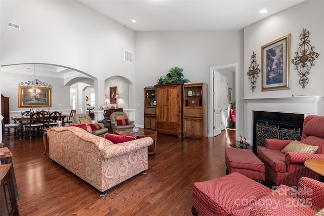 2021 Pinyon Ln, Lancaster, SC 29720 - living area with arched walkways, a towering ceiling, a fireplace, wood finished floors, and recessed lighting