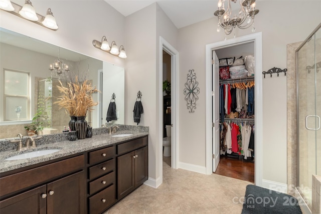 2021 Pinyon Ln, Lancaster, SC 29720 - full bathroom featuring a chandelier, a shower stall, double vanity, a walk in closet, and tile patterned floors