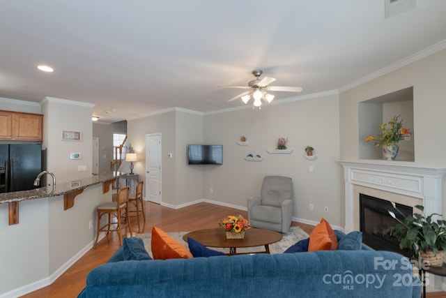 916 Coffee Tree Ln, Rock Hill, SC 29732 - living room featuring light wood-type flooring, ceiling fan, baseboards, ornamental molding, and a glass covered fireplace