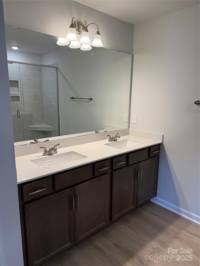 2910 Sloan Dr, Charlotte, NC 28208 - full bathroom with wood finished floors, a stall shower, double vanity, and baseboards