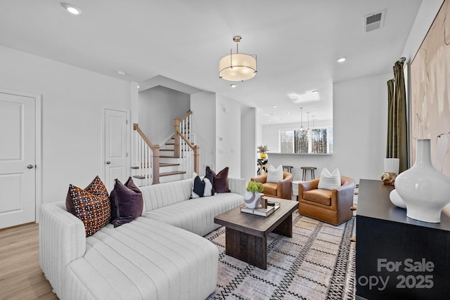 living area featuring stairway, light wood-style flooring, and recessed lighting