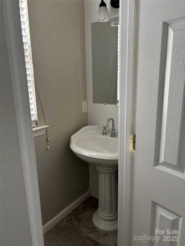 10826 Claude Freeman Dr, Charlotte, NC 28262 - bathroom featuring baseboards, backsplash, and a sink