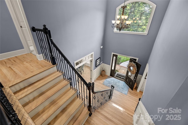 9021 Unbridle Ln, Waxhaw, NC 28173 - stairs with a chandelier, wood finished floors, and a high ceiling