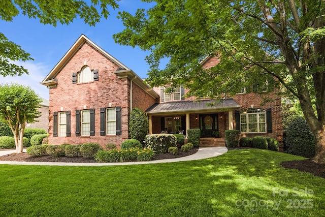 9021 Unbridle Ln, Waxhaw, NC 28173 - traditional-style home with covered porch, brick siding, a front lawn, a standing seam roof, and metal roof