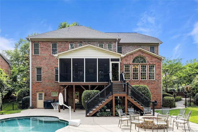 9021 Unbridle Ln, Waxhaw, NC 28173 - back of house featuring a sunroom, a patio, brick siding, and a fire pit