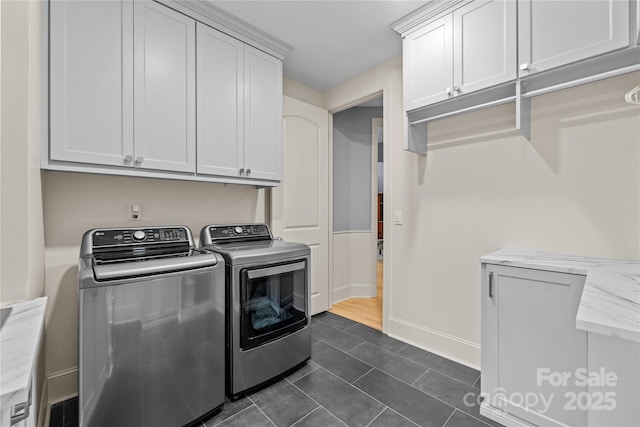 9021 Unbridle Ln, Waxhaw, NC 28173 - laundry room with washer and clothes dryer, cabinet space, dark tile patterned floors, and baseboards