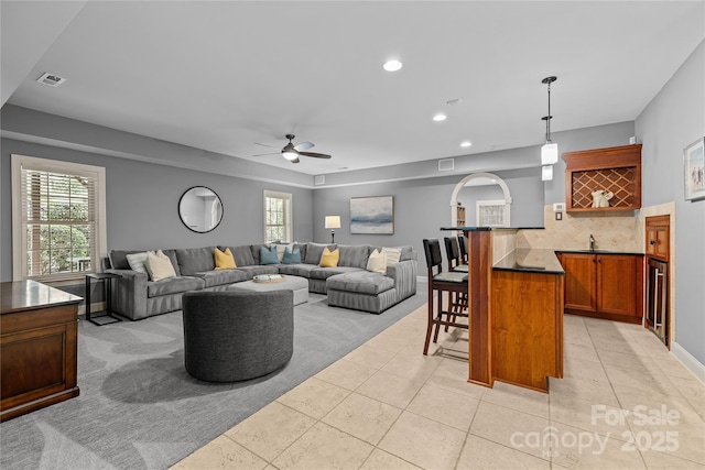 9021 Unbridle Ln, Waxhaw, NC 28173 - living area with ceiling fan, bar with sink, light tile patterned flooring, and recessed lighting