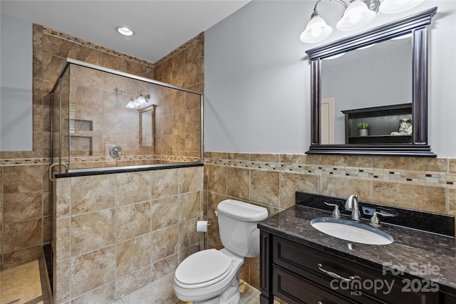9021 Unbridle Ln, Waxhaw, NC 28173 - bathroom featuring tile walls, vanity, a shower stall, toilet, and wainscoting