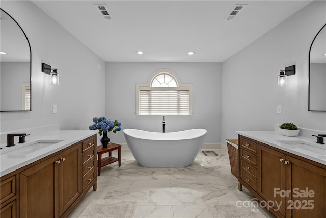 9021 Unbridle Ln, Waxhaw, NC 28173 - bathroom with two vanities, a soaking tub, recessed lighting, and marble finish floors