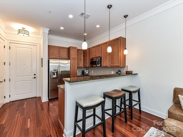 2810 Selwyn Ave Unit 104, Charlotte, NC 28209 - kitchen featuring stainless steel appliances, brown cabinetry, dark wood-type flooring, backsplash, and a breakfast bar area