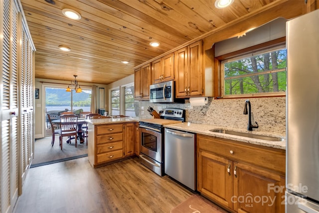 214 Sequoyah Trl, Robbinsville, NC 28771 - kitchen with stainless steel appliances, wooden ceiling, a sink, brown cabinetry, and light wood-style flooring