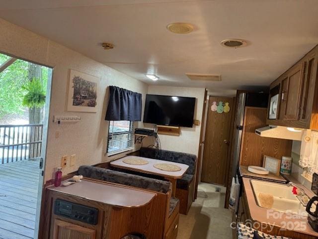 kitchen with brown cabinets, a sink, and extractor fan