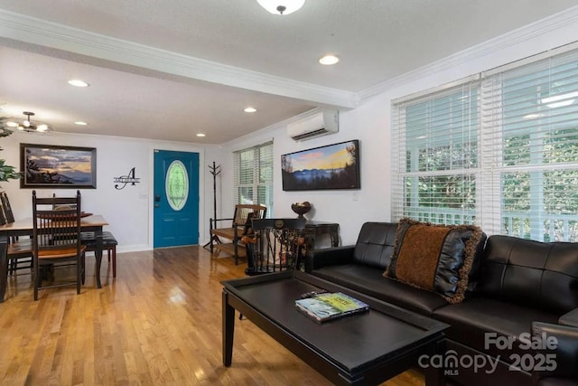 living room featuring an AC wall unit, ornamental molding, recessed lighting, wood finished floors, and baseboards