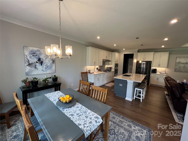 7057 Kingfisher Way, Belmont, NC 28012 - dining area with crown molding, a chandelier, dark wood finished floors, and recessed lighting