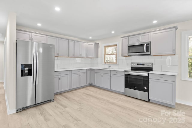 174 Maske Rd, Mount Gilead, NC 27306 - kitchen with stainless steel appliances, gray cabinets, backsplash, light wood-style floors, and recessed lighting