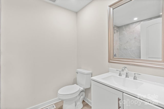 174 Maske Rd, Mount Gilead, NC 27306 - bathroom with baseboards, toilet, vanity, and wood finished floors