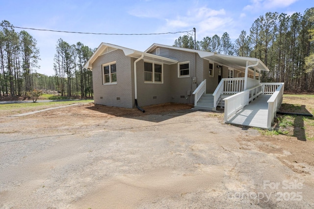 174 Maske Rd, Mount Gilead, NC 27306 - view of front facade featuring crawl space, a porch, brick siding, and driveway