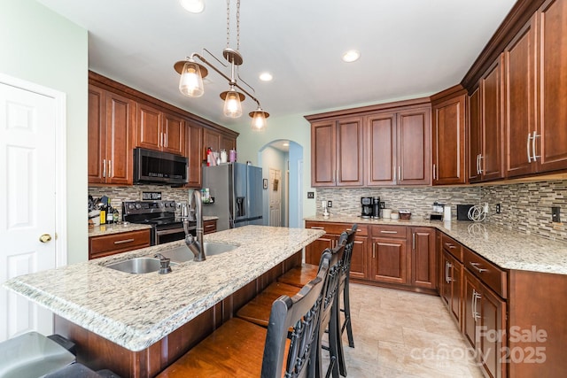 8927 Comstock Ct, Locust, NC 28097 - kitchen featuring stainless steel appliances, arched walkways, decorative backsplash, a breakfast bar, and recessed lighting