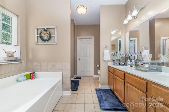 8927 Comstock Ct, Locust, NC 28097 - bathroom with tile patterned floors, double vanity, a bath, toilet, and baseboards