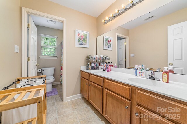 8927 Comstock Ct, Locust, NC 28097 - bathroom with double vanity, toilet, and baseboards