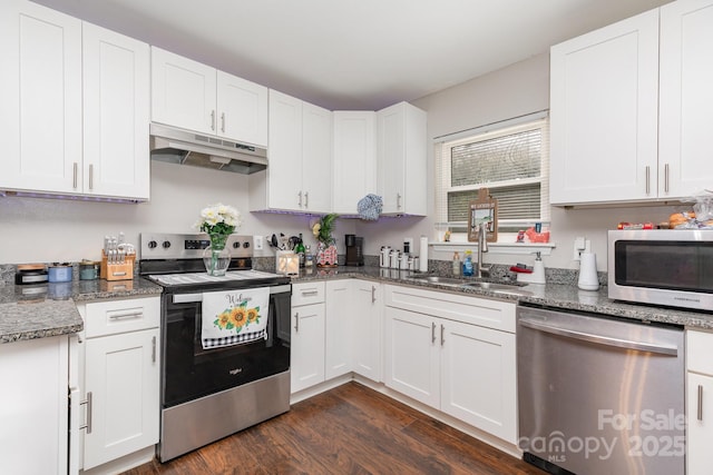 1016 W 10th Ave, Gastonia, NC 28052 - kitchen featuring appliances with stainless steel finishes, under cabinet range hood, a sink, dark wood-style flooring, and white cabinetry