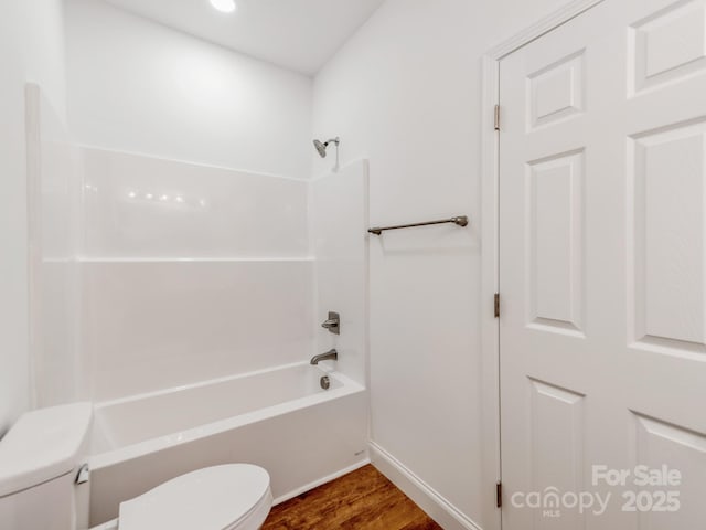 full bath featuring toilet, wood finished floors, bathtub / shower combination, and baseboards