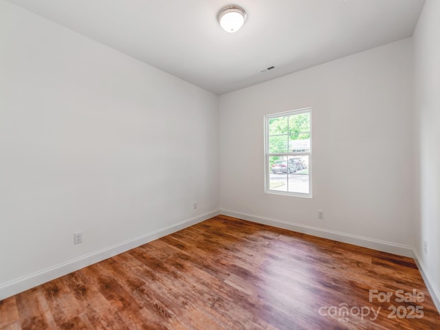 unfurnished room featuring wood finished floors and baseboards