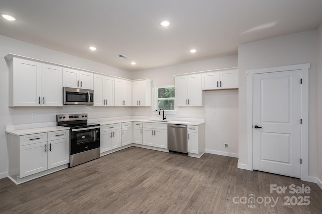 1941 32nd St NE, Hickory, NC 28601 - kitchen with appliances with stainless steel finishes, a sink, white cabinetry, dark wood finished floors, and recessed lighting