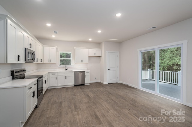 1941 32nd St NE, Hickory, NC 28601 - kitchen featuring appliances with stainless steel finishes, dark wood-style flooring, white cabinetry, recessed lighting, and light countertops