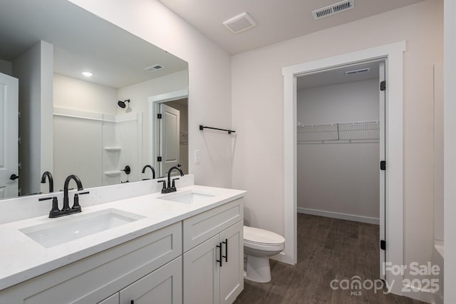 1941 32nd St NE, Hickory, NC 28601 - bathroom with a shower, toilet, wood finished floors, a spacious closet, and double vanity