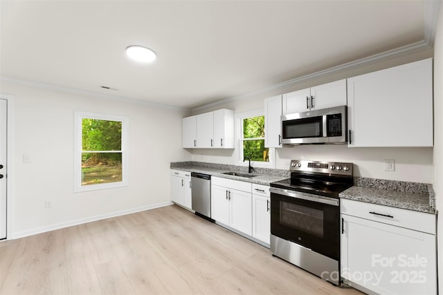 1155 Cedar Grove Ln, Rock Hill, SC 29732 - kitchen featuring appliances with stainless steel finishes, a sink, ornamental molding, light wood-style flooring, and white cabinetry