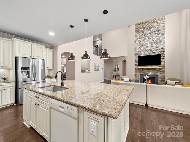1190 Arges River Dr, Fort Mill, SC 29715 - kitchen with white dishwasher, arched walkways, stainless steel refrigerator with ice dispenser, a sink, and a fireplace